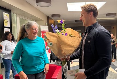 Einrichtungsleitung überreicht an eine Mitarbeiterin zum Dienstjubiläum 25 Jahre einen Blumenstrauß