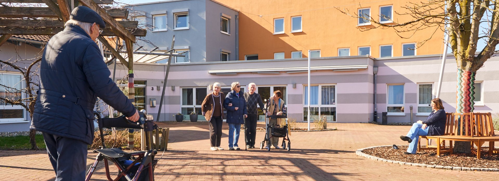 Menschen stehen vor dem Eingang eines Seniorenzentrums
