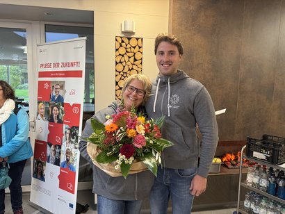 Die Einrichtungsleiung überreicht zum Dienstjubiläum der Pflegedienstleiterin einen bunten Blumenstrauß