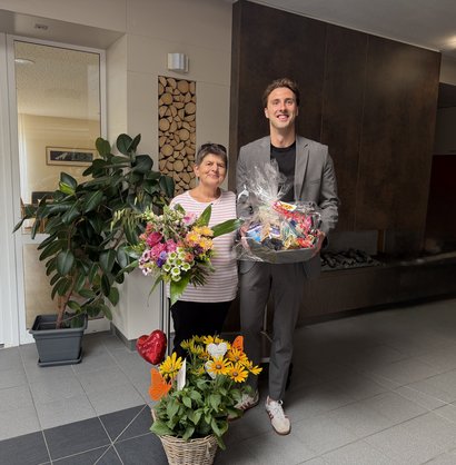Einrichtungsleitung überreicht zur Rente einen Präsentkorb.