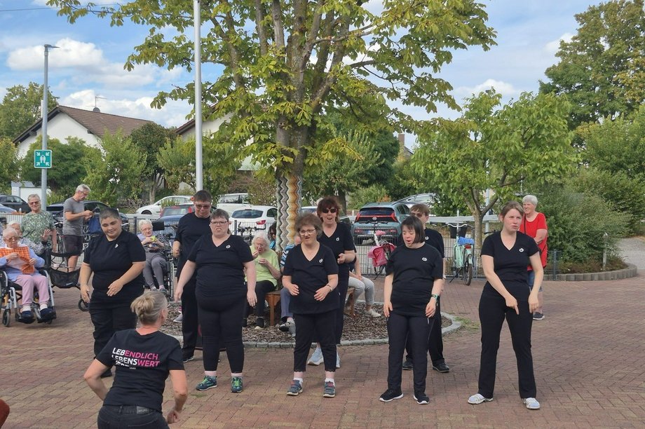 Tanzgruppe „Dancing Queens“ der Lebenshilfe tritt bei einem Sommerfest vor Bewohnerinnen und Bewohnern einer Pflegeeinrichtung auf.