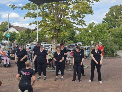 Tanzgruppe „Dancing Queens“ der Lebenshilfe tritt bei einem Sommerfest vor Bewohnerinnen und Bewohnern einer Pflegeeinrichtung auf.