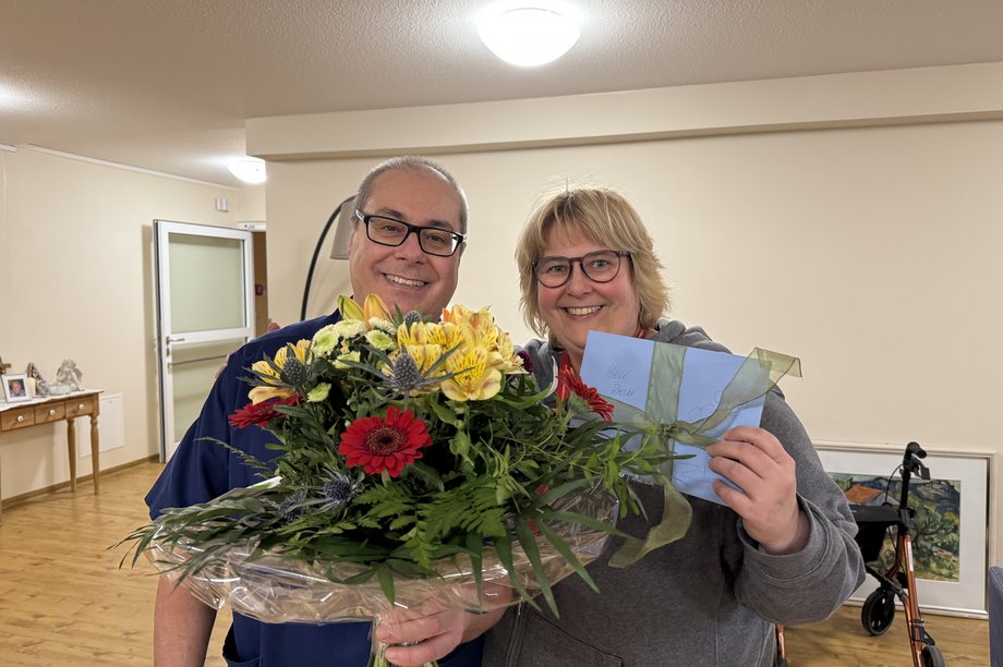 Pflegedienstleiterin übreicht einen Blumenstrauß