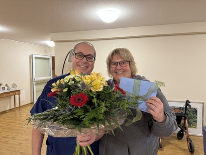 Pflegedienstleiterin übreicht einen Blumenstrauß