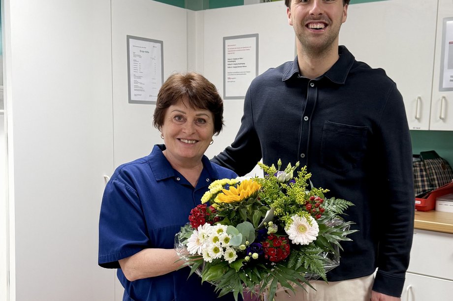 Einrichtungsleitung gratuliert mit bunten Strauß zu 10 Jahre Dienstjubiläum