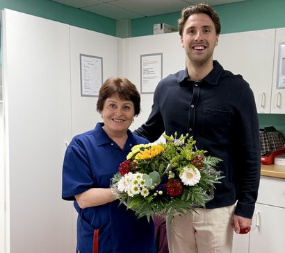 Einrichtungsleitung gratuliert mit bunten Strauß zu 10 Jahre Dienstjubiläum