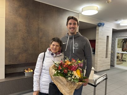 Die Einrichtungsleitung überreicht zum Dienstjubiläum einen bunten Blumenstrauß