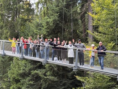 Mitarbeidende des AWO Seniorenzentrum Rheinaue stehen auf einer Hängebrücke